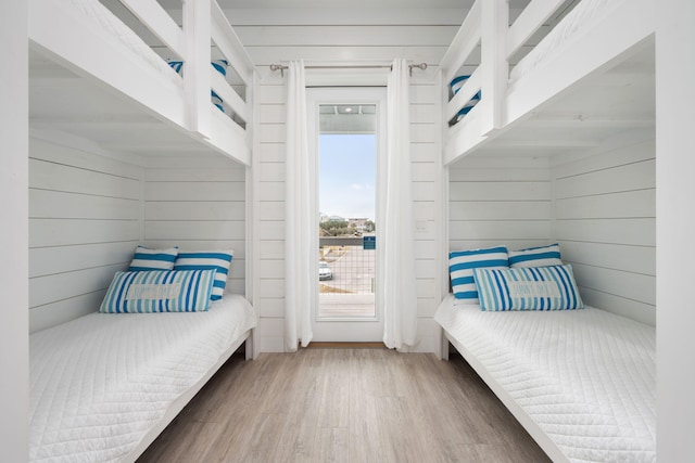 bedroom with wood-type flooring and wood walls