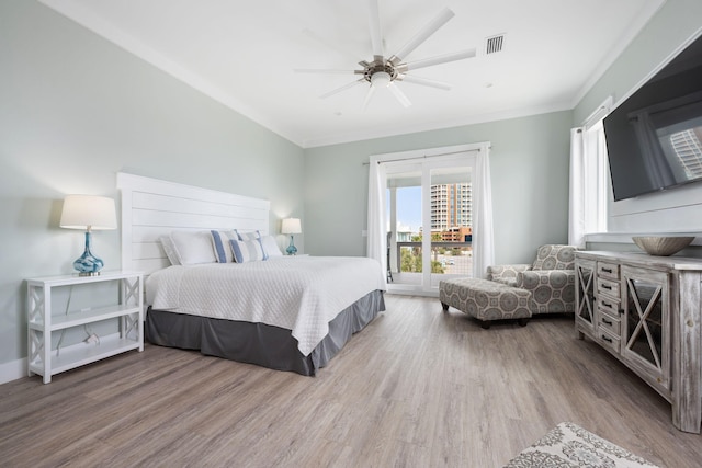 bedroom with crown molding, hardwood / wood-style flooring, and ceiling fan