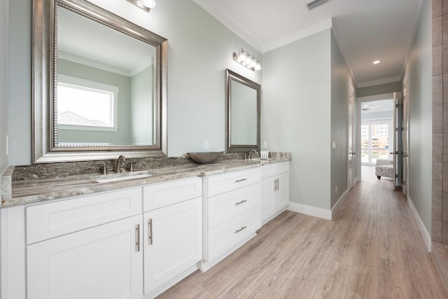 bathroom featuring crown molding, hardwood / wood-style floors, and vanity