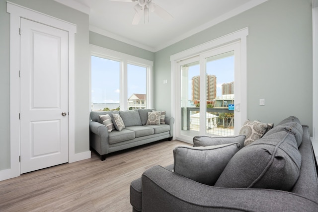 living room featuring crown molding, light hardwood / wood-style flooring, and ceiling fan