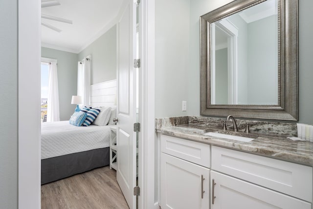 bathroom featuring vanity, hardwood / wood-style floors, and crown molding