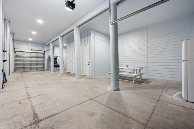 garage featuring white refrigerator and a garage door opener