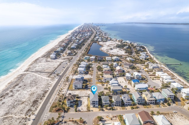 bird's eye view featuring a water view and a beach view