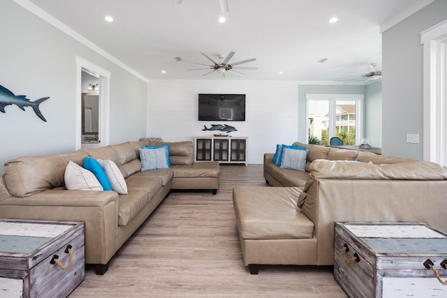 living room with crown molding, ceiling fan, and light wood-type flooring