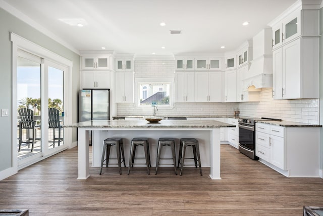 kitchen with white cabinetry, stainless steel appliances, a breakfast bar area, and a kitchen island