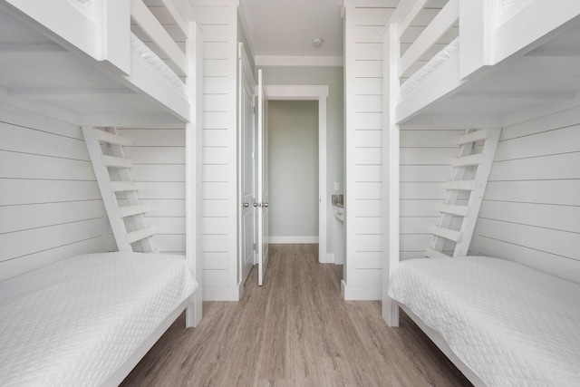 bedroom featuring hardwood / wood-style floors and wood walls