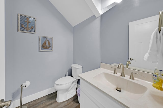 bathroom featuring vanity, wood-type flooring, vaulted ceiling, and toilet