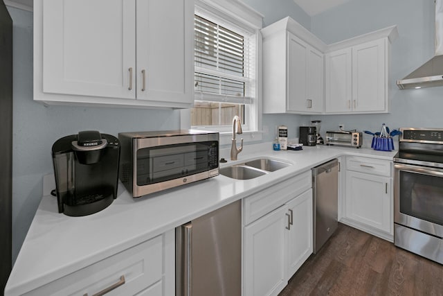 kitchen featuring wall chimney exhaust hood, sink, white cabinetry, dark hardwood / wood-style floors, and stainless steel appliances