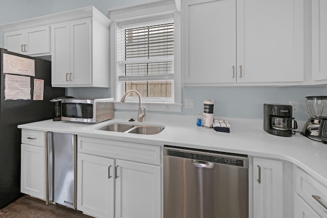 kitchen with appliances with stainless steel finishes, sink, and white cabinets