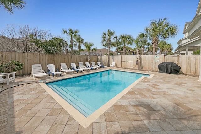 view of pool with a grill and a patio area