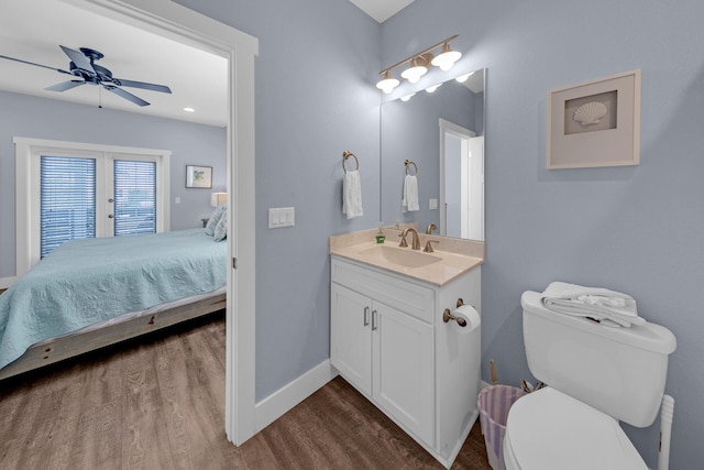 bathroom with hardwood / wood-style flooring, vanity, ceiling fan, toilet, and french doors