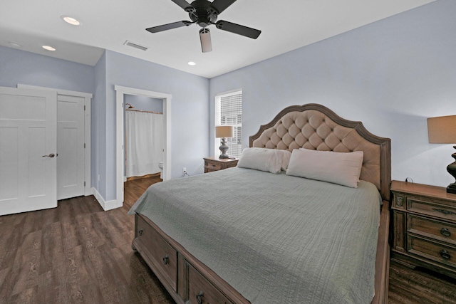 bedroom featuring ensuite bath, dark hardwood / wood-style floors, and ceiling fan