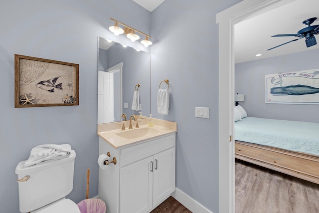 bathroom featuring vanity, wood-type flooring, toilet, and ceiling fan