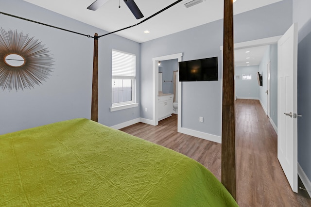 unfurnished bedroom featuring ensuite bathroom and hardwood / wood-style floors