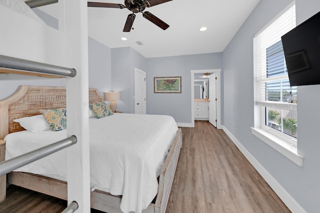 bedroom featuring ceiling fan, ensuite bathroom, and light hardwood / wood-style floors