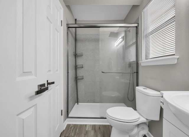 bathroom with vanity, toilet, a shower with door, and hardwood / wood-style floors