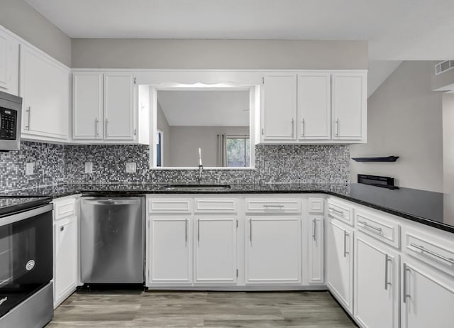 kitchen featuring stainless steel appliances, white cabinetry, sink, and light hardwood / wood-style floors