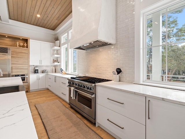 kitchen with white cabinets, custom exhaust hood, high end appliances, light stone counters, and wood ceiling