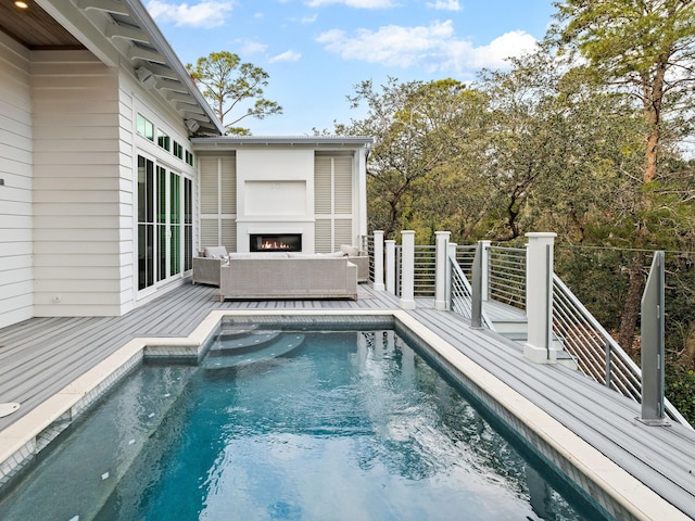 view of swimming pool featuring an outdoor living space with a fireplace