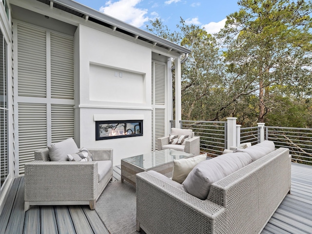 wooden terrace with an outdoor living space with a fireplace