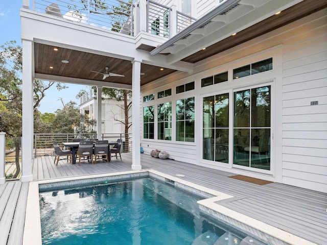 view of swimming pool featuring a deck and ceiling fan