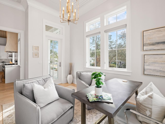 living room with an inviting chandelier, light hardwood / wood-style flooring, and ornamental molding