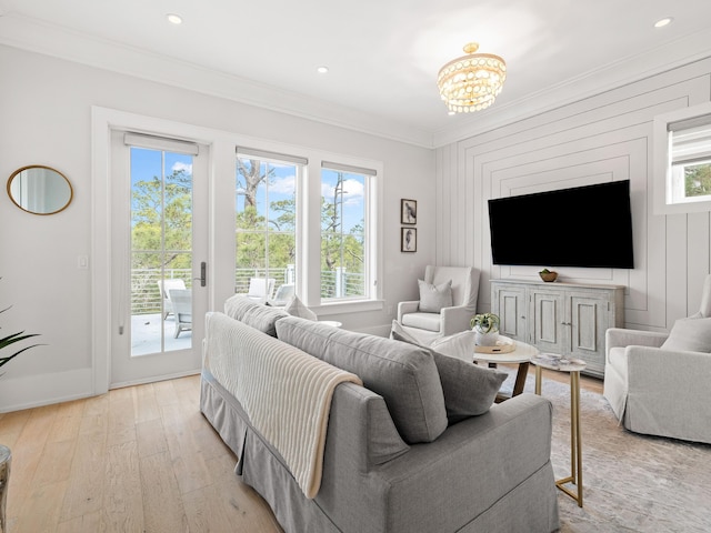 living room with ornamental molding, a chandelier, a healthy amount of sunlight, and light wood-type flooring