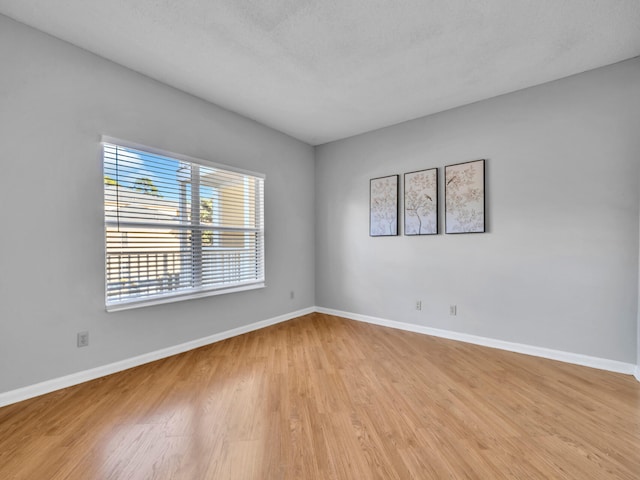 empty room with light wood-style flooring and baseboards