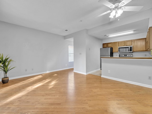 unfurnished living room with a ceiling fan, light wood-style flooring, and baseboards