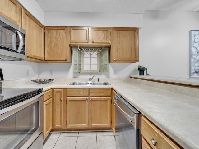 kitchen featuring stainless steel appliances, light countertops, a sink, and light tile patterned floors