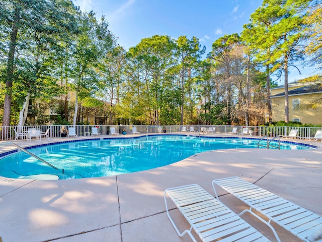 community pool with fence and a patio