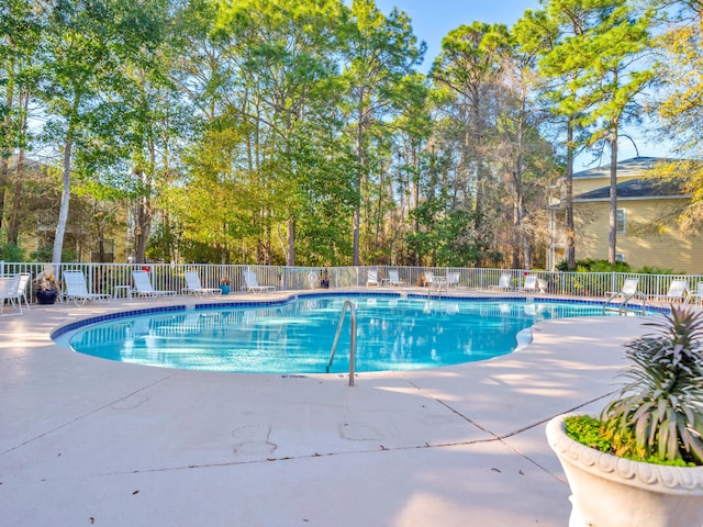 pool with a patio and fence