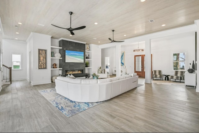 living room featuring wood ceiling, a fireplace, and light hardwood / wood-style flooring