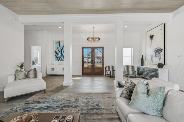 living room featuring dark wood-type flooring, decorative columns, and french doors