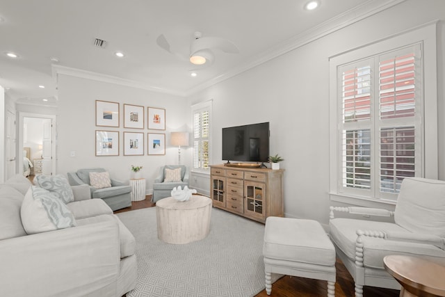 living room with ornamental molding, wood-type flooring, and ceiling fan