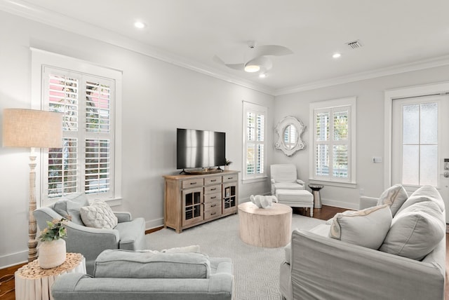 living room with hardwood / wood-style flooring, crown molding, and ceiling fan