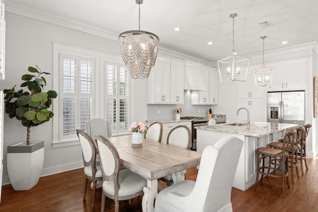 dining area featuring ornamental molding, dark wood-type flooring, sink, and an inviting chandelier