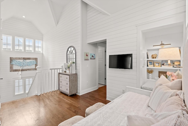 living room with dark hardwood / wood-style floors, high vaulted ceiling, and built in shelves