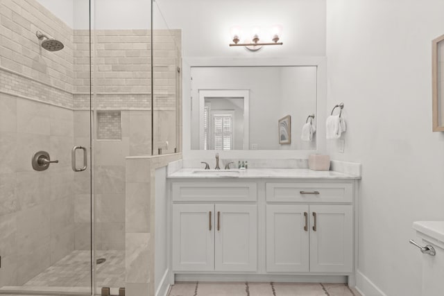 bathroom with vanity, a shower with door, and toilet