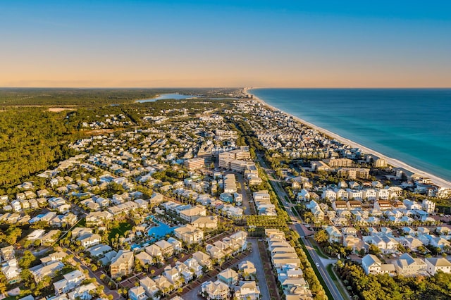 aerial view at dusk with a view of the beach and a water view