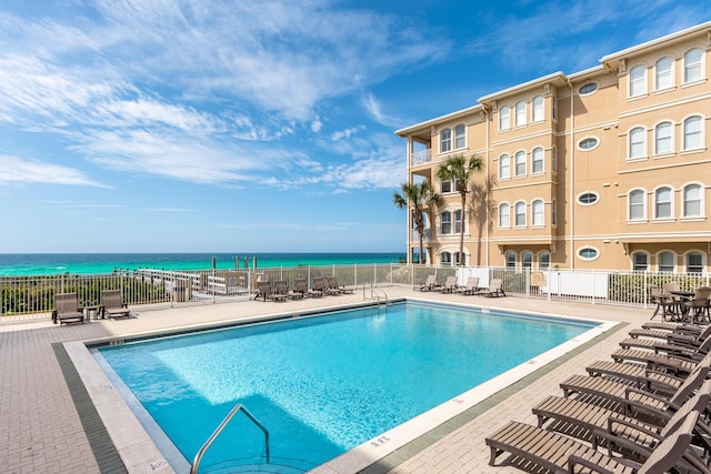 view of pool with a water view and a patio area