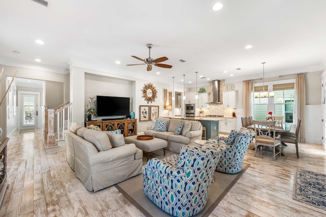 living room featuring plenty of natural light, ornamental molding, and light wood-type flooring