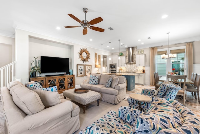 living room with crown molding, ceiling fan with notable chandelier, and light hardwood / wood-style flooring