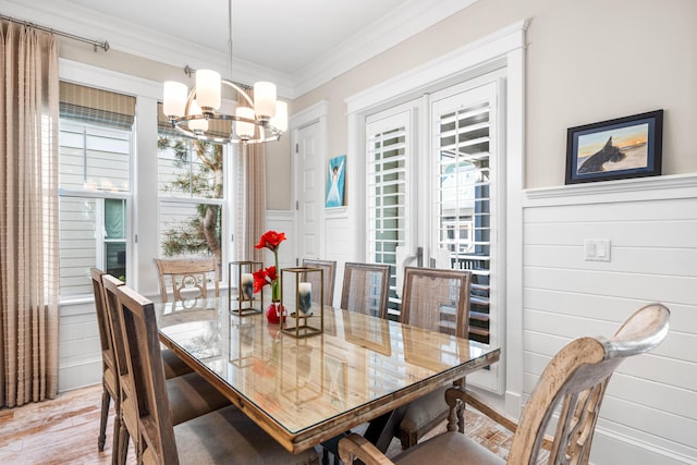 dining area featuring an inviting chandelier, crown molding, and light hardwood / wood-style floors