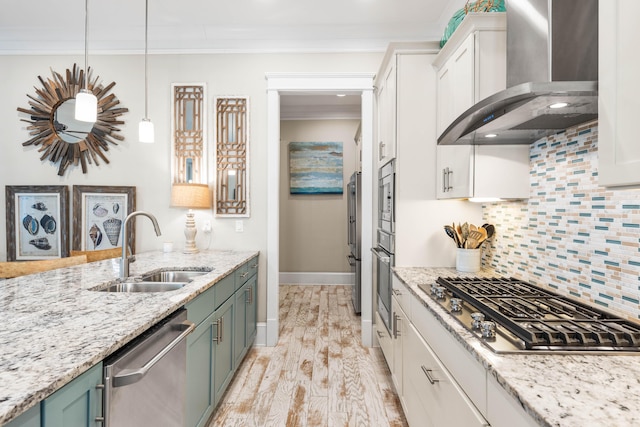 kitchen with appliances with stainless steel finishes, wall chimney exhaust hood, sink, and white cabinets