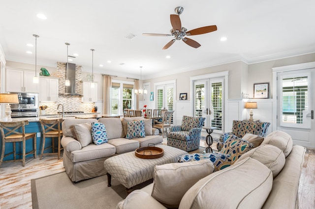 living room with light hardwood / wood-style flooring, ornamental molding, french doors, and ceiling fan