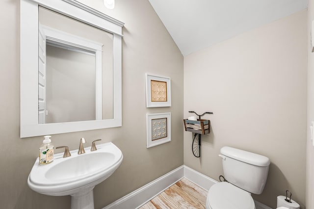 bathroom featuring lofted ceiling, sink, and toilet