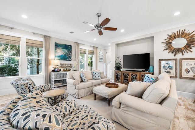 living room featuring light hardwood / wood-style flooring, ornamental molding, and ceiling fan