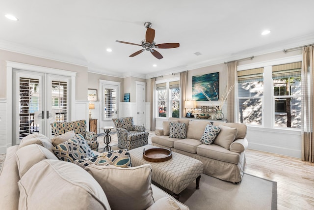 living room with ornamental molding, light hardwood / wood-style flooring, ceiling fan, and french doors