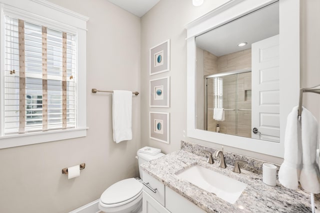 bathroom with vanity, a wealth of natural light, toilet, and walk in shower